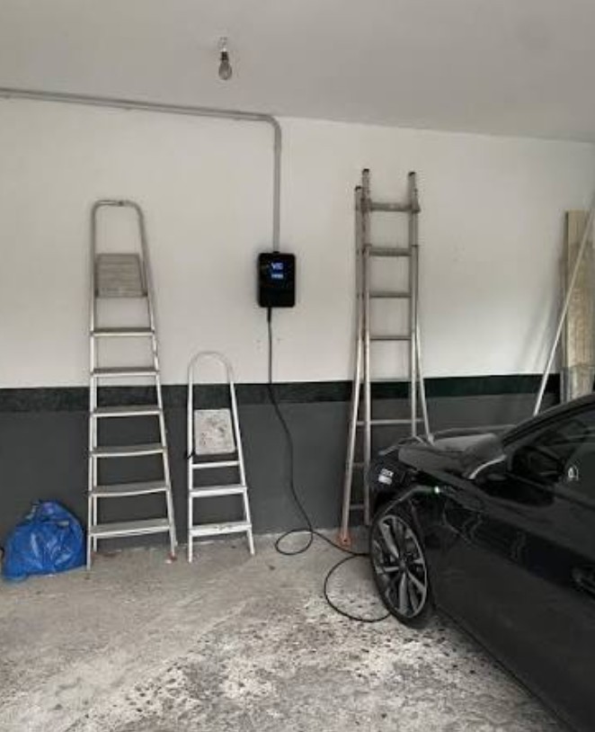 Borne de recharge V2C installée en garage avec véhicule électrique en charge