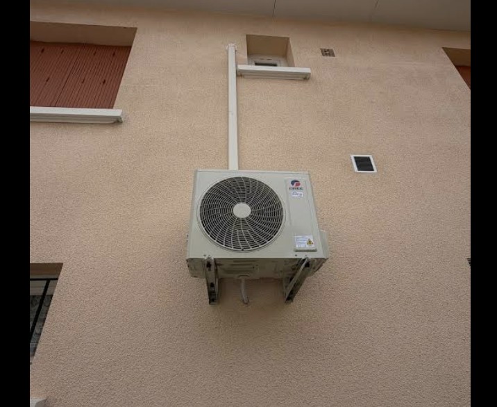 Groupe extérieur de climatisation fixé en façade avec goulotte de liaison