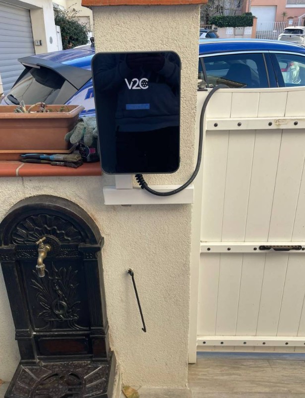 Borne de recharge V2C fixée sur un pilier extérieur avec support